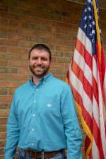 Jesse Trout standing in front of an American flag